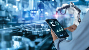 Smart industry automation manufacturing control concept Hands holding tablet on blurred automation machine as background